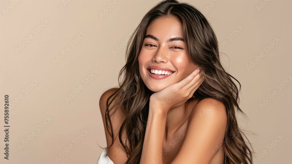 Smiling woman with a hand gently touching her face, displaying clear skin and a joyful expression. Smiling woman with a hand gently touching her face, displaying clear skin and a joyful expression.