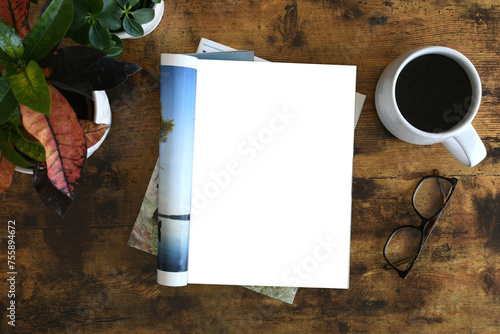 An open magazine laying on a table or desk with a white blank page for mock up. photo