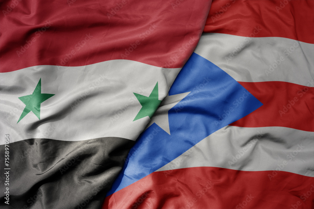 big waving national colorful flag of puerto rico and national flag of syria .