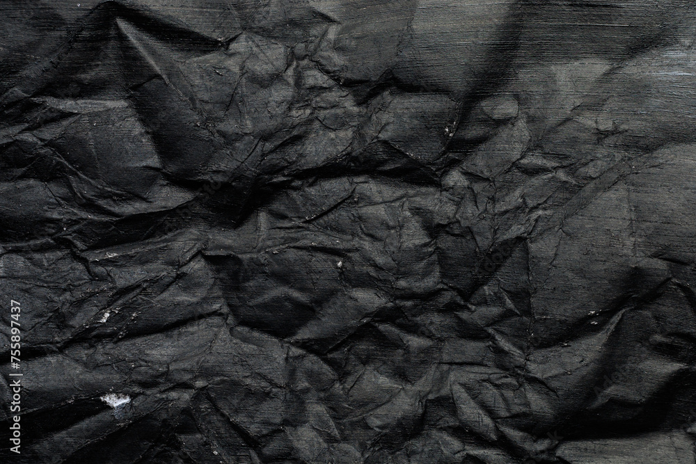 Crumpled paper canvas painted with black paint. Blank for design, graphic resource