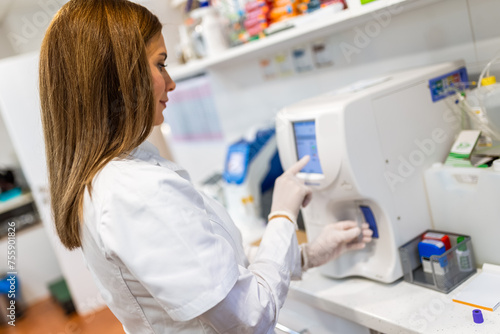 Wallpaper Mural Female veterinarian working in laboratory. Vet doctor is examining sample at animal hospital. She is wearing uniform. Torontodigital.ca