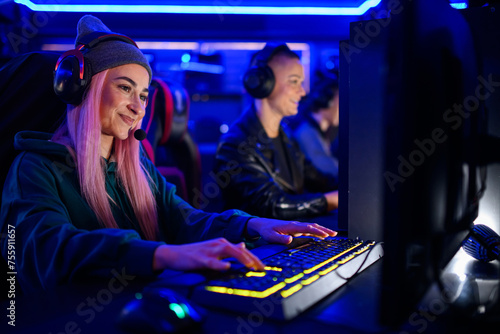 Female esport gamer with a cap and a pink hair playing online video games