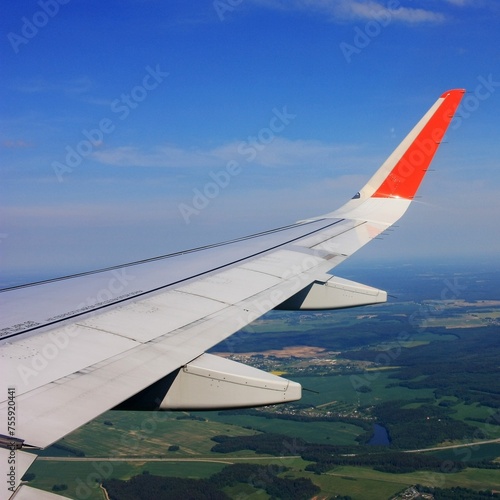 Airplane wing in blue sky with clouds
