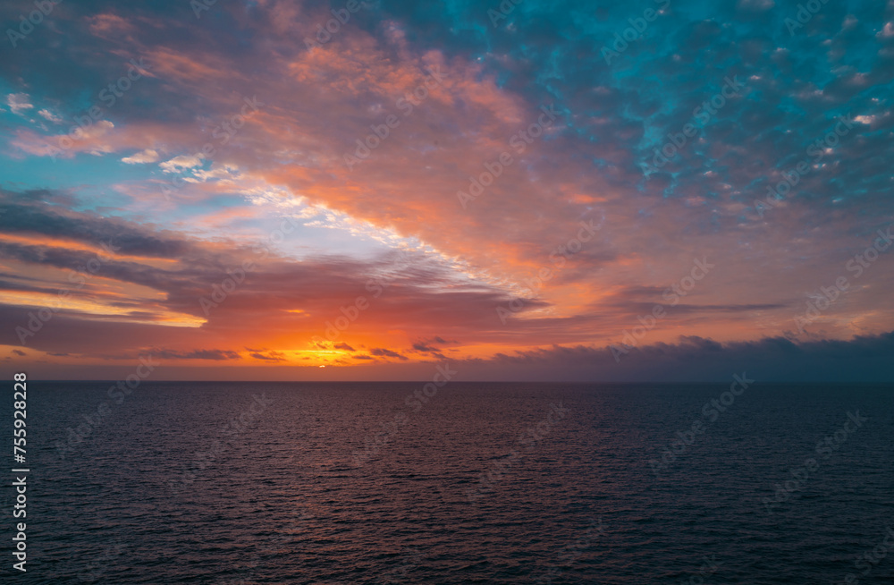 Sunset in the sea with beautiful clouds. Sunrise ocean seascape.