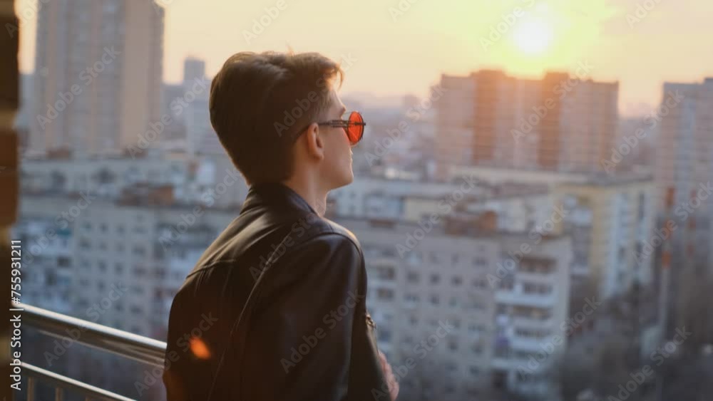 Happy teenager dancing while standing on the balcony at sunset, slow motion Happy teenager dancing while standing on the balcony at sunset, slow motion