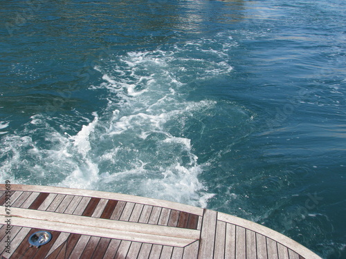Small boat stirring a trail of seafoam