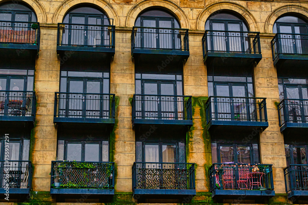 Facade of a vintage building with ornate windows and balconies in Leeds, UK.