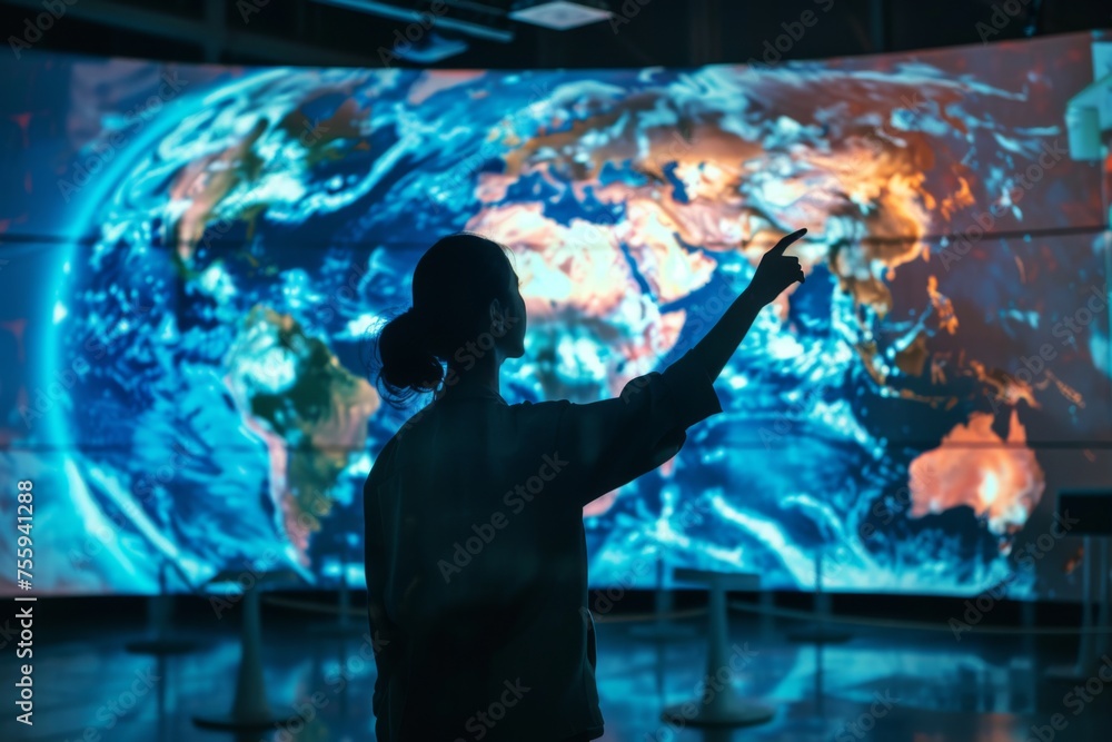 Person pointing at a large screen with Earth data - A person is actively engaging with a wall-sized digital globe projection analyzing climatic or geographical data Person pointing at a large screen with Earth data - A person is actively engaging with a wall-sized digital globe projection analyzing climatic or geographical data