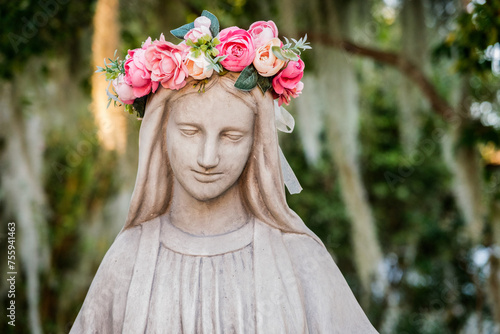 фотографія Virgin Mary statue with a crown of flowers outside