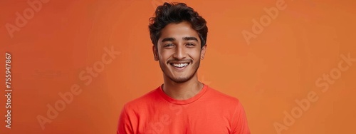 Vibrant Joy: Smiling Youth in Red-Orange, Holding Smartphone in Exciting Pose generative ai © RamvijayB