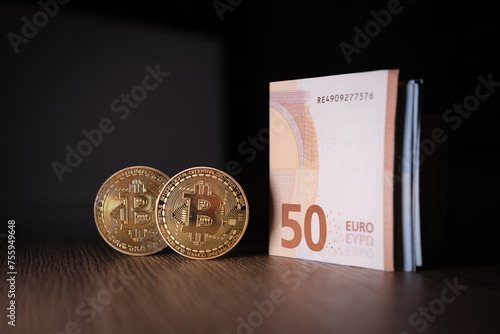 2 Bitcoin coins are next to a bundle of euro banknotes
