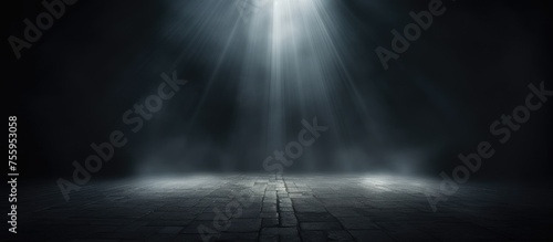 In a dark room, a spotlight illuminates a wooden floor creating a dramatic atmosphere. The contrast between the darkness and the bright light creates a lens flare effect photo