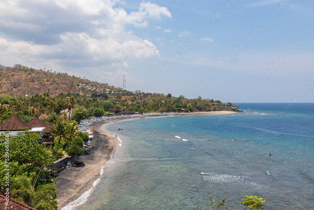 Amed beach with many snorkeling tourists in water. Bali, Indonesia