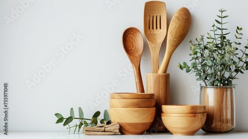 Minimalistic eco-friendly kitchen utensils and bamboo bowls on a white surface  concept of sustainable living