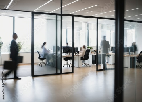 a group of people in an office setting with glass walls and a person walking  © Universeal