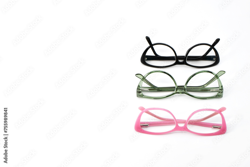 Pairs of glasses with pink, green and black frames in a row isolated on a plain white background. Copy space to left. Eyesight concept. Pairs of glasses with pink, green and black frames in a row isolated on a plain white background. Copy space to left. Eyesight concept.