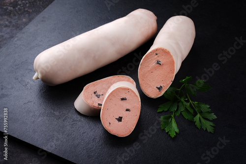Traditionelle deutsche Kalbsleberwurst mit Bauernbrot angeboten als Nahaufnahme auf einer schwarzen Platte mit Textfreiraum