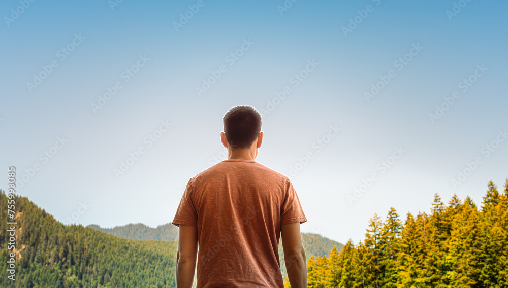 Man standing in the mountains looking into the distant view 