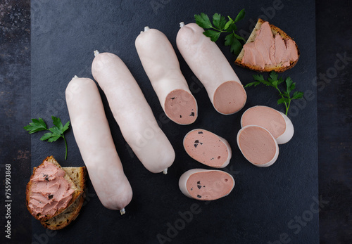 Traditionelle deutsche Kalbsleberwurst mit Bauernbrot angeboten als Nahaufnahme auf einer schwarzen Design Platte mit Textfreiraum