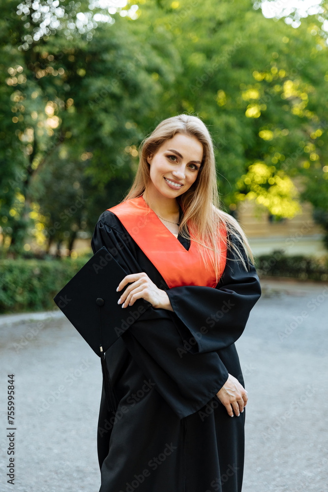 Beautiful university graduate in a black gown. The happy student successfully completed university and obtained a master's degree. Beautiful university graduate in a black gown. The happy student successfully completed university and obtained a master's degree.