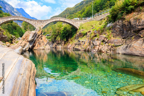 Ancient double arch stone Roman bridge (Ponte dei Salti) over the clear water of the Verzasca river in Lavertezzo ,Verzasca Valley, Ticino Canton, Switzerland photo