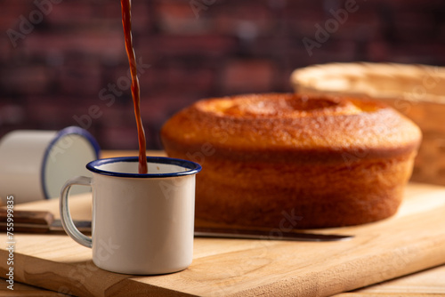 Fototapeta Naklejka Na Ścianę i Meble -  Orange cake and cup of coffee, beautiful orange cake and a cup of coffee and accessories on rustic wooden surface, dark background, selective focus.