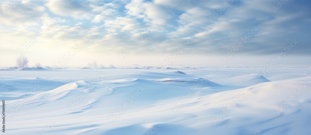 The sun shines through the cumulus clouds over a snowy field, creating a beautiful natural landscape with blue skies and a fluid horizon