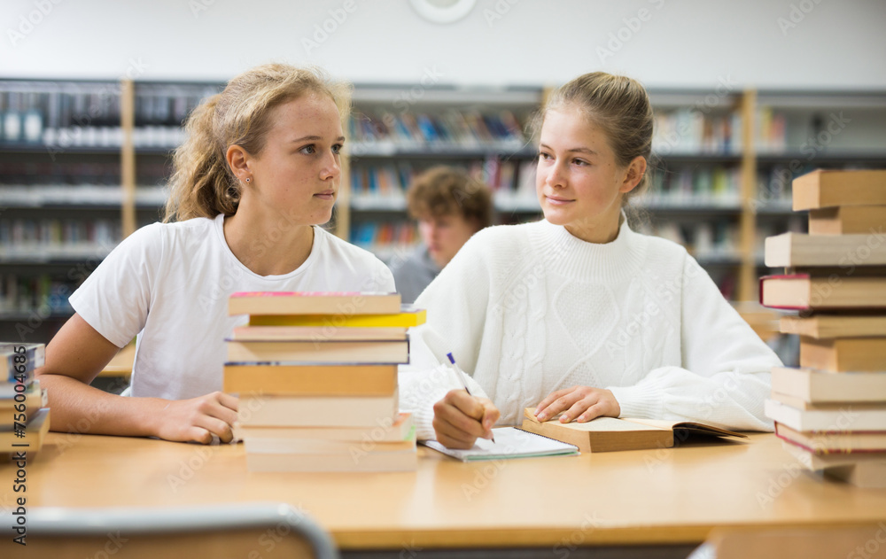 Fototapeta premium Two friends are studying in the school library. Exam preparation