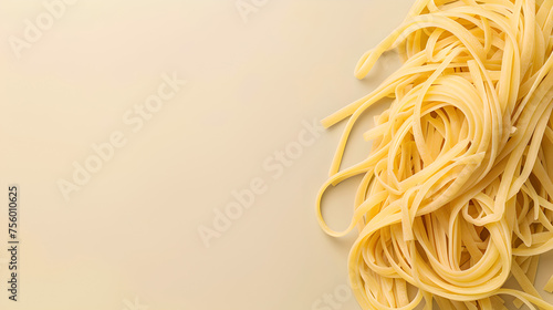 fresh handmade spaghetti pasta on side of pastel colored light cream yellow background with copy space  photo