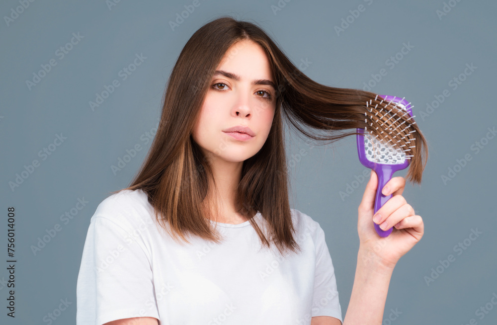 Portrait of beautiful young woman combing her hair, smiling. Female brushing healthy hair with comb. Cares about a healthy and clean hair. Beauty salon concept. Portrait of beautiful young woman combing her hair, smiling. Female brushing healthy hair with comb. Cares about a healthy and clean hair. Beauty salon concept.