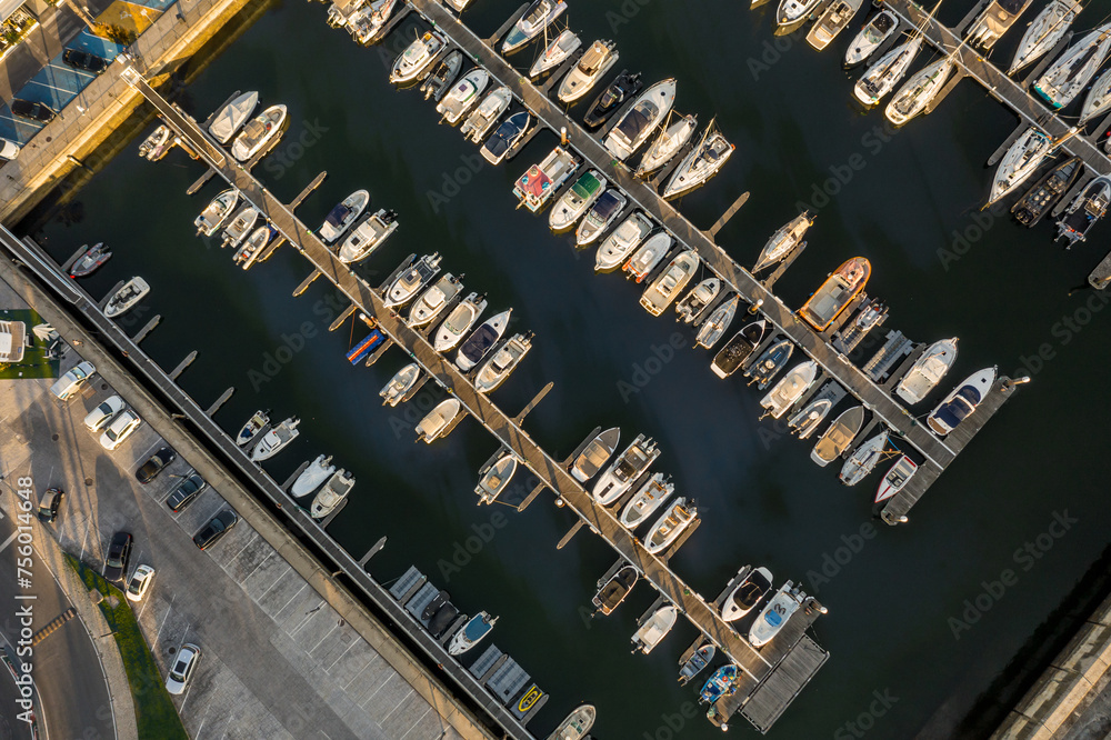 Aerial overhead view of a row of yachts in marina with moored