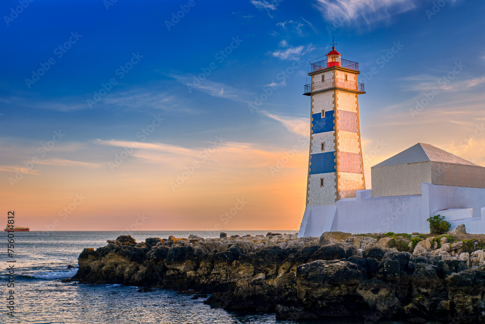 Colorful sunset on sea shore and Santa Marta lighthouse in Cascais