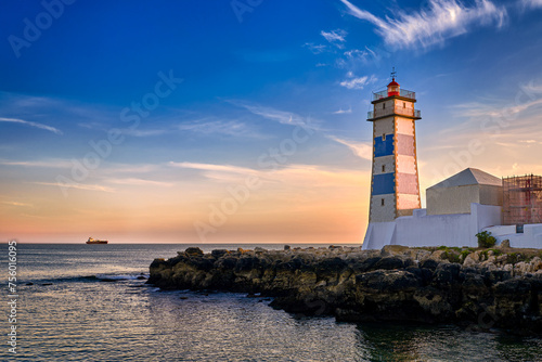 Obraz na płótnie Dramatic sunset on sea shore and Santa Marta lighthouse in Cascais w salonie