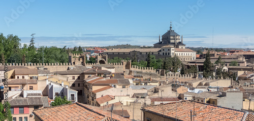 Aerial panoramic view at the Toledo city downtown, top roof buildings, buildings inside Toledo fortress, school and church of San Juan Bautista as background