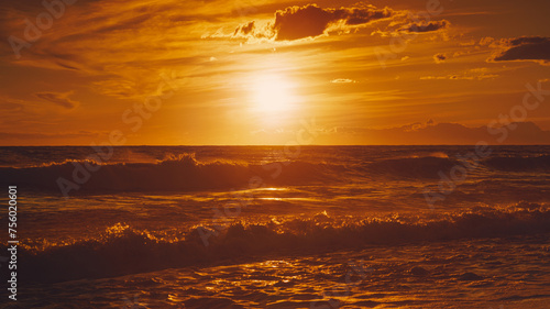 Fototapeta Naklejka Na Ścianę i Meble -  Alanya, Antalya, Türkiye, Turkey, Panoramic view of the undulating Mediterranean Sea with waves at sunset, bright orange sun in the sky and clouds around