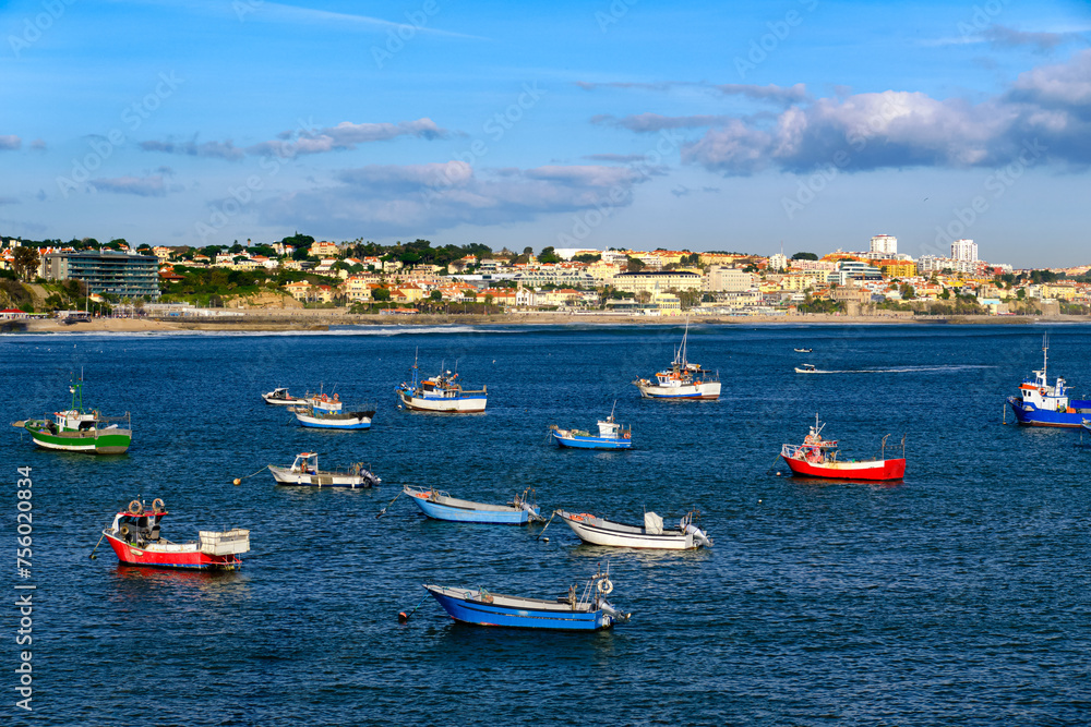 Small boats on sunny day near coastline and seaside town, Cascais