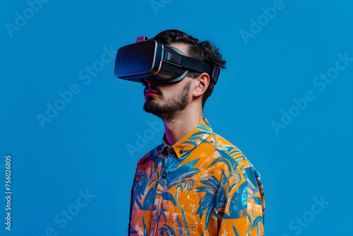 Young man with virtual reality headset. Male in VR glasses on blue background. VR, AR, metaverse, future, gadgets, technology, education online, study, video game concept. Futuristic technology © Melanthe