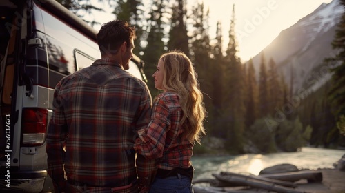couple drinking coffee, in the woods, standing in front of rv