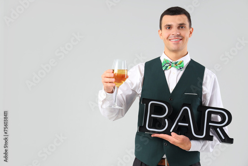 Young barman with wine on g...