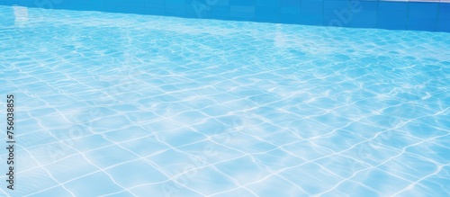 Close up of a sparkling swimming pool with azure water and white tiles, creating a mesmerizing pattern. The fluid, electric blue liquid invites recreation under the horizon with gentle wind waves