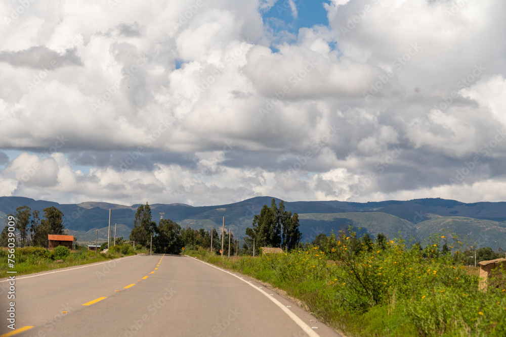 beautiful road, with mountains in the background and green vegetation on a cloudy day