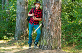 Firewood as a renewable energy source. Lumberjack with axe on forest background. Deforestation is a major cause of land degradation and destabilization of natural ecosystems.