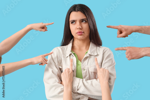 Valokuva People pointing at sad young woman on blue background