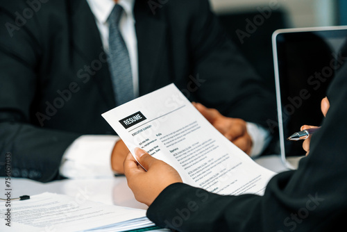 Human resources department manager reads CV resume document of an employee candidate at interview room. Job application, recruit and labor hiring concept. uds