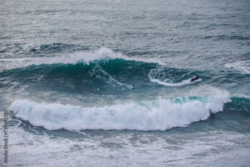 big wave surfer and jet ski in giant wave at Nazaré Praia do Norte