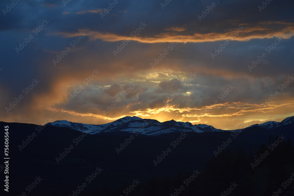 Sun Glowing Through the Clouds at Sunset Over the Rocky Mountains