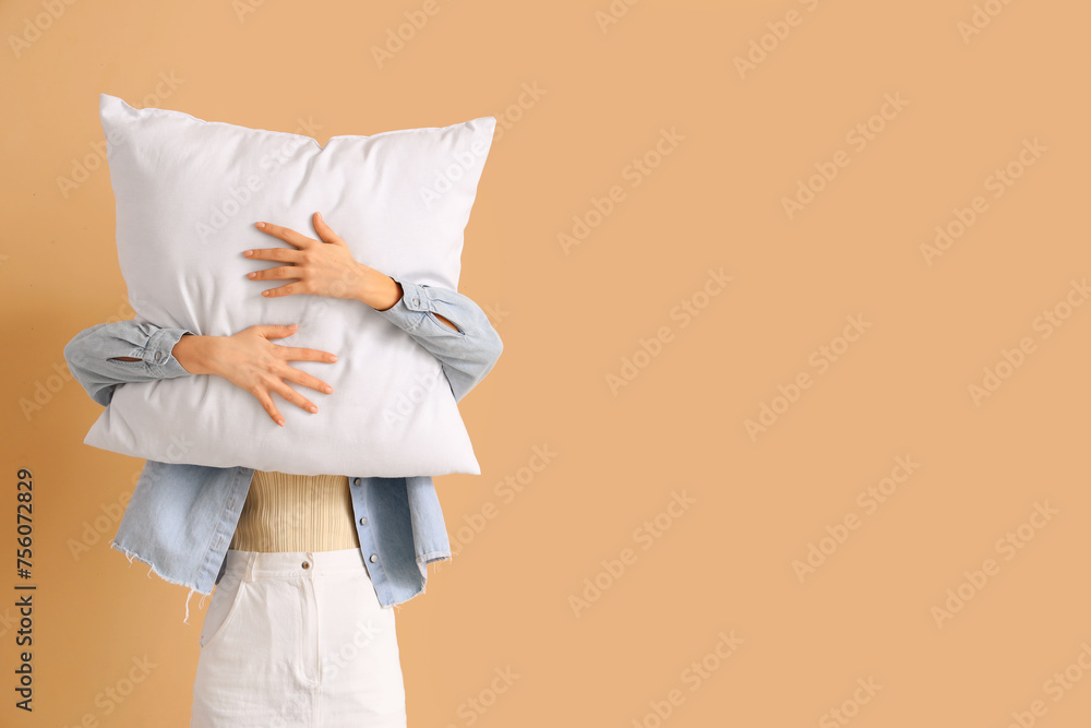 Woman with white pillow on beige background Woman with white pillow on beige background