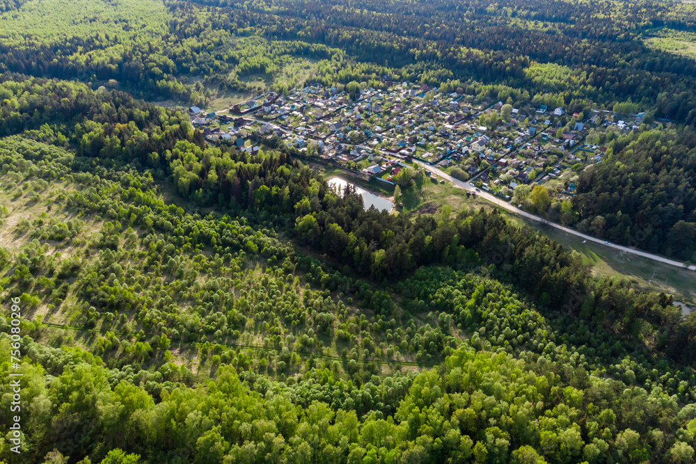 Aerial view of a holiday village surrounded by forests and fields