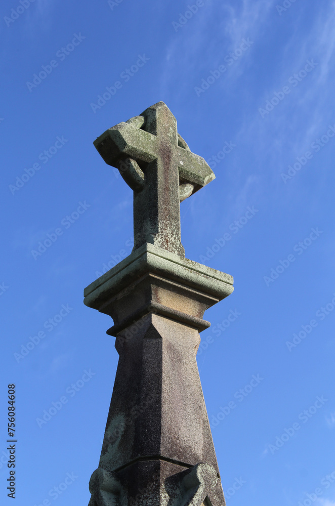 Statue of a celtic cross against a blue sky background