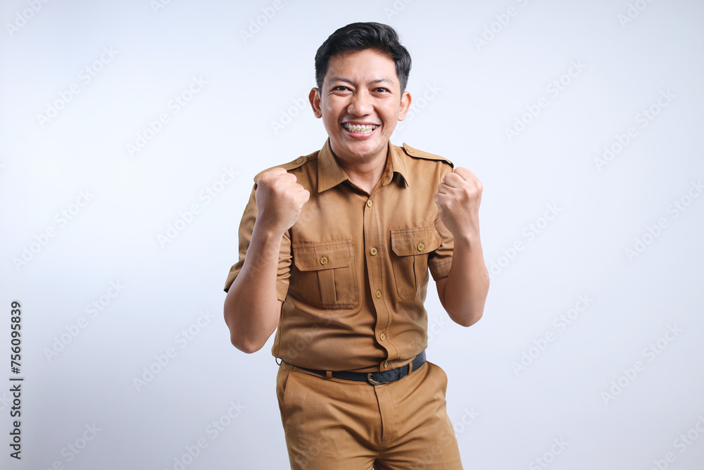 Asian civil servants or state civil servants in brown uniform raised fist doing successful expression. Asian civil servants or state civil servants in brown uniform raised fist doing successful expression.